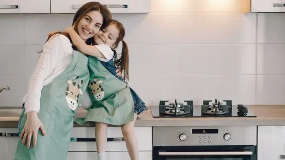 daughter hugging mom in kitchen