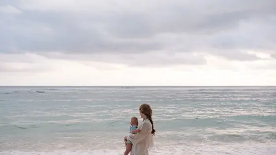 baby and mother looking at ocean